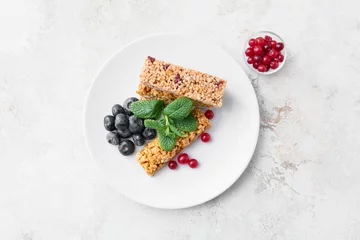 Zelfklevend Fotobehang Plate with healthy cereal bars and berries on light background © Pixel-Shot