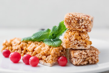 Plate with healthy cereal bars and berries on light background