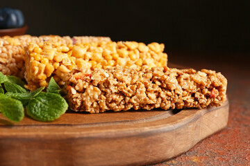 Board with healthy cereal bars and blueberries on grunge background