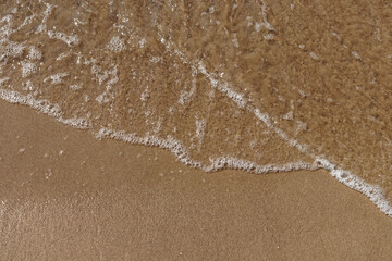 Tidal waves with ripples and foam on sea coast