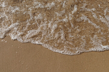 Tidal waves with ripples and foam on sea coast