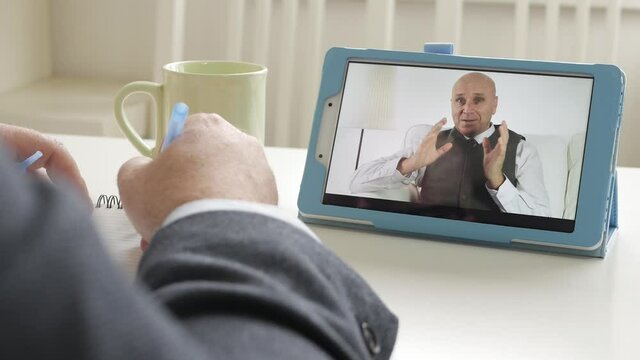 Video Business Meeting Between Two Businessmen's Using an Electronic Tablet. Online Application Via a Mobile Internet Connection.