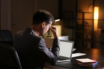 Tired businessman working in office late at night