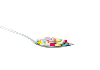Side view of colorful medicine pills in spoon.