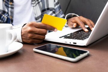 Black man making payment with plastic card during online shopping