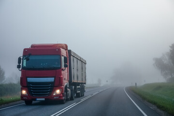 Obraz na płótnie Canvas Truck on a country road in the fog in summer. Poor visibility conditions on the road.