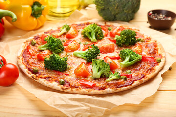 Parchment with tasty vegetarian pizza on light wooden background, closeup