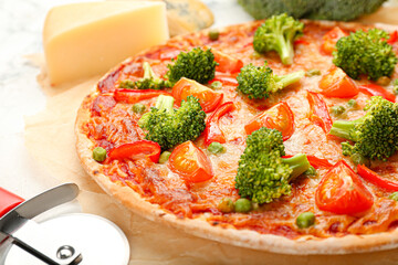Parchment with tasty vegetarian pizza on light background, closeup