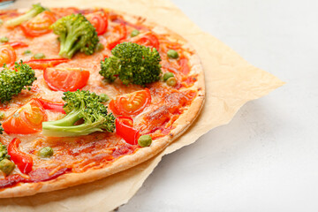 Parchment with tasty vegetarian pizza on light background, closeup