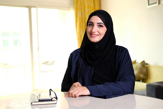 Happy smiling Emirati Arab woman wearing traditional Abaya and Hijab