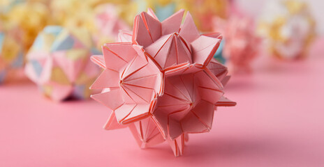 Set of multicolor handmade modular origami balls or Kusudama Isolated on pink background. Visual...