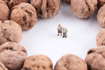 Miniature old man surrounded by walnuts
