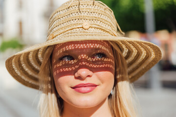 Woman in straw hat on sunny day in city