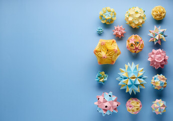 Set of multicolor handmade modular origami balls or Kusudama Isolated on blue background. Visual...