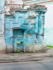 Ancient ruined blue building. Destroyed cyan house. Travel street photo. Turquoise weathered wall.