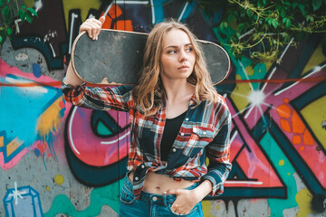 Woman riding a skateboard on colorful street art. Skater girl on a longboard. Cool female skateboarder at sunset. Carefree female skater 20s enjoying freedom youth lifestyle Hobby © anna.stasiia