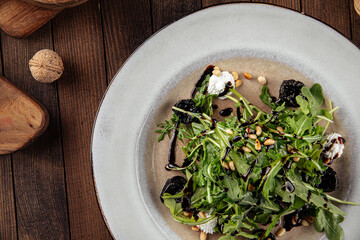 Beet root and arugula salad with cheese on the wooden background