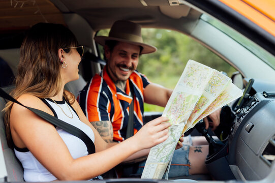 Traveling couple reading map in car during trip