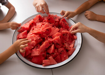 Children hold pieces of watermelon. Selective focus. Top view