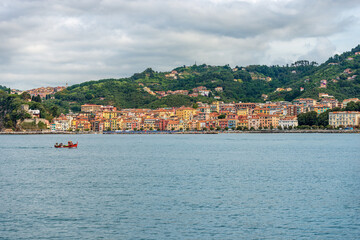Fototapeta premium The small village of San Terenzo seen from the sea, Gulf of La Spezia, municipality of Lerici, Mediterranean sea, Liguria, Italy, Europe. 