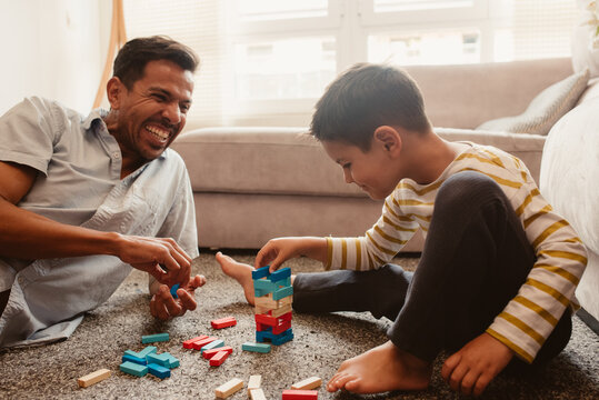 Father and son playing with construction pieces in the dining room