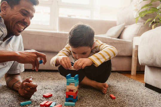 Father and son playing with construction pieces in the dining room
