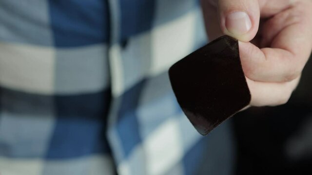 The man unpacks and peels the tape from the protective layer of the anti-tobacco patch. Quitting smoking, close-up