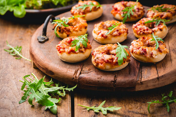 Small pizza in donut shape with rocket (arugula) and fresh salad