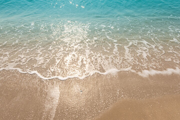 Fototapeta na wymiar Blue ocean waves Sunlight Reflection Sand Beach background