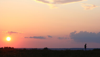 the silhouette of a man against the background of the setting sun