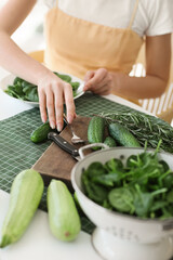 Young woman with fresh vegetables in kitchen, closeup