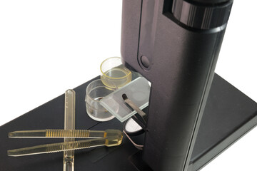 biological microscope, accessories, specimens in glass jars, transparent tweezers with ribbed handles, adjustment spatula-dropper. closeup