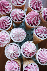 Top view on sweet waffle cones with pink cream on a special stand