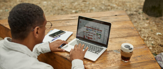 Laptop screen with schemes during work of young man