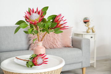 Interior of modern room with sofa and protea flowers on table
