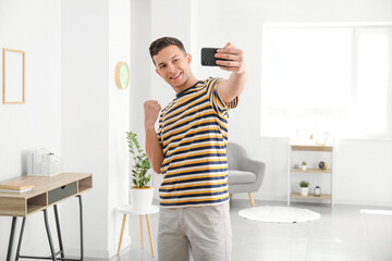 Young man taking selfie at home