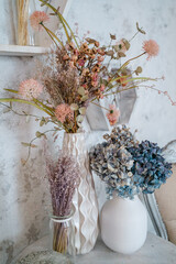 Vases with dried flowers on the table in the interior