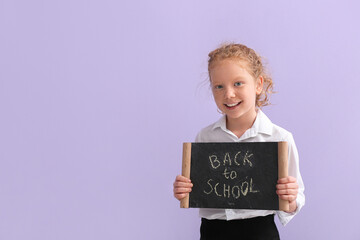 Cute little girl holding chalkboard with text BACK TO SCHOOL on color background