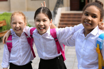 Cute little schoolgirls after classes outdoors