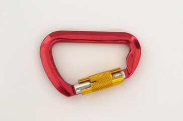 Red carabiner for climbers on a white background