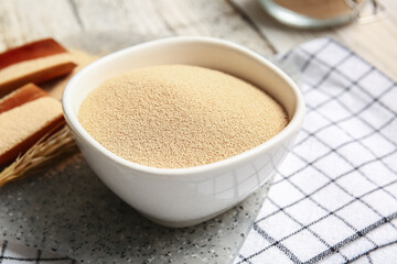 Bowl with active dry yeast on table