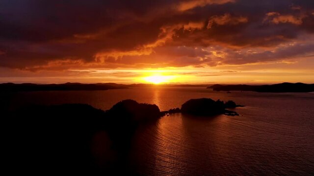 Beautiful Sunset Above The Sea In Poroporo Island, Bay Of Islands In New Zealand - aerial pullback