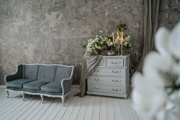 Grey sofa with chest of drawers against a gray wall