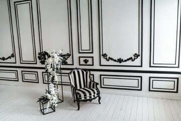 Black and white wall decoration with armchair and flowers