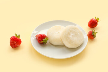 Plate with tasty Japanese mochi and strawberry on color background