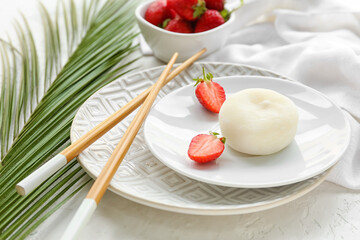 Plates with tasty Japanese mochi and strawberry on light background