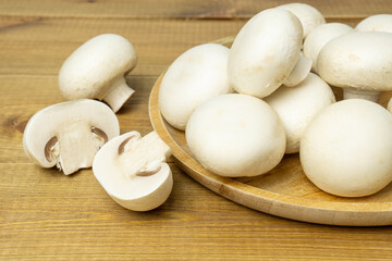 Raw fresh mushroom champignons on wooden table.