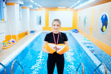 Young woman trainer swimming coach in pool water for children and adults