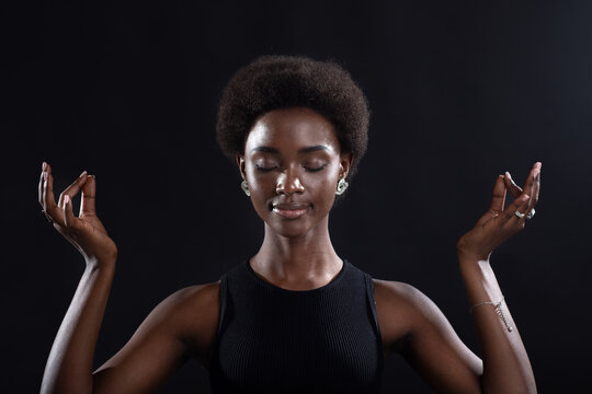 Studio portrait of african american female model showing zen yoga mudra or okay sign gesture. Woman inner peace, health and meditation