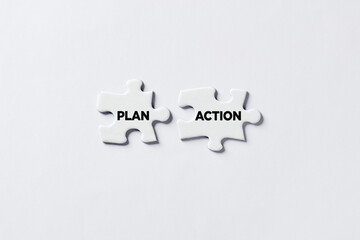 Two Jigsaw puzzle pieces is connecting with the words plan and action. To take action and to realize the plans